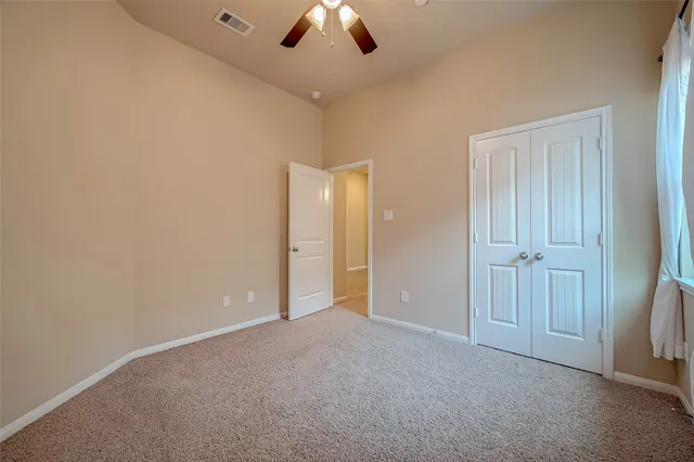 a view of an empty room and a ceiling fan window