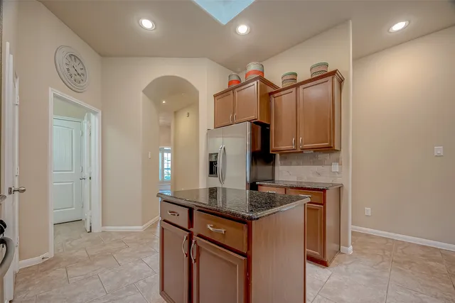 a kitchen with granite countertop a sink a stove and a refrigerator