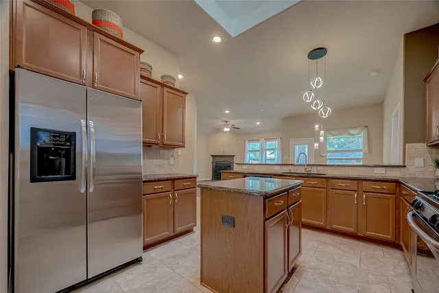 a kitchen with stainless steel appliances granite countertop a sink a stove and refrigerator