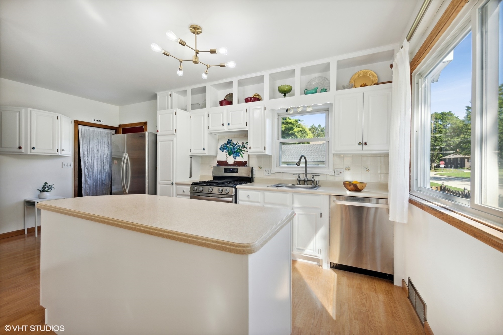 401 Lyon Avenue Wheaton, IL 60187 - Photo 3 of 34 a kitchen with stainless steel appliances a refrigerator a stove a sink dishwasher and white cabinets with wooden floor