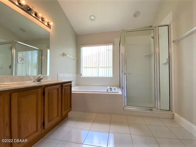 a spacious bathroom with a tub sink shower and mirror