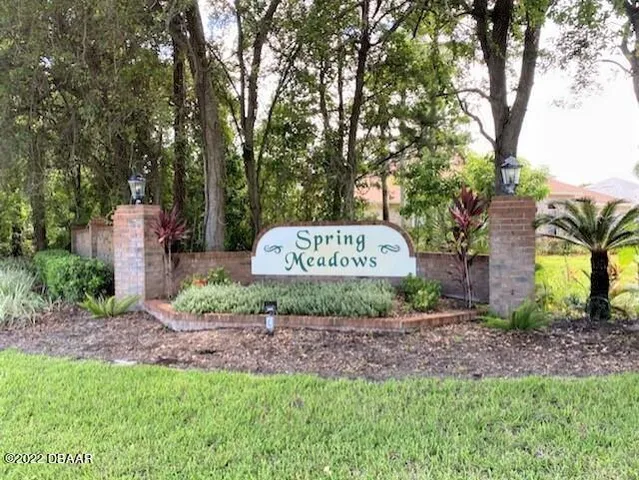 a sign board with a park bench and trees
