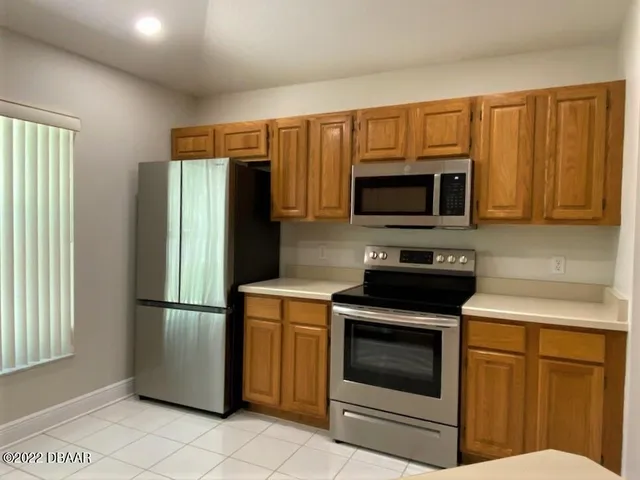 a kitchen with stainless steel appliances granite countertop a refrigerator stove and microwave