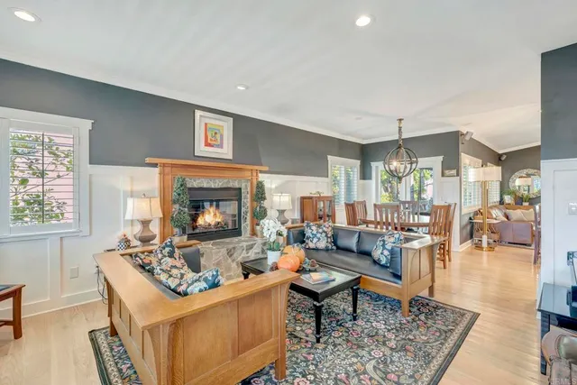 a living room with furniture a dining table and a large window