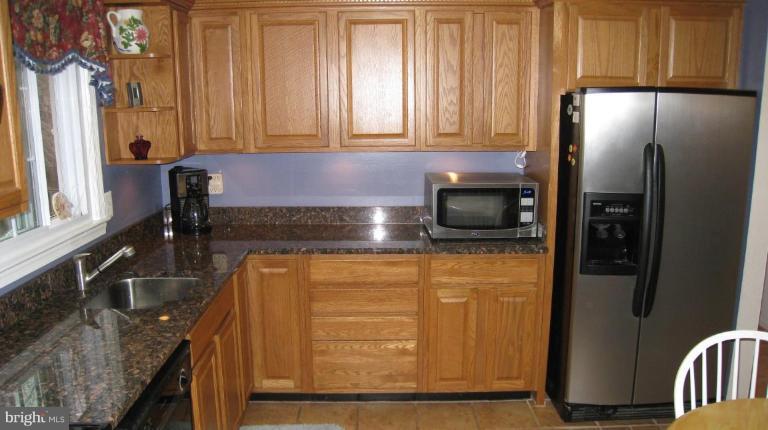 8532 Riverside Road Alexandria, VA 22308 - Photo 19 of 22 a kitchen with granite countertop stainless steel appliances a refrigerator and a sink