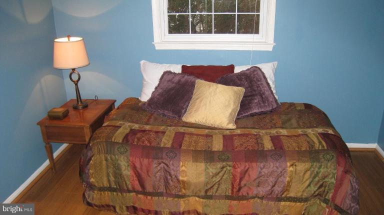 8532 Riverside Road Alexandria, VA 22308 - Photo 7 of 22 a bed sitting in a bedroom next to a window