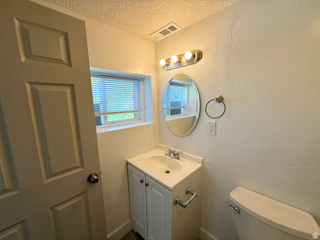 548 27th Street Ogden, UT 84403 - Photo 7 of 13 Half bath featuring a textured ceiling, a textured wall, and vanity