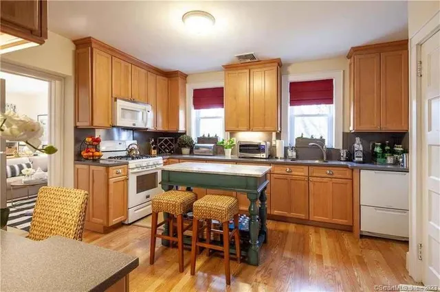 a kitchen with white cabinets sink and stainless steel appliances