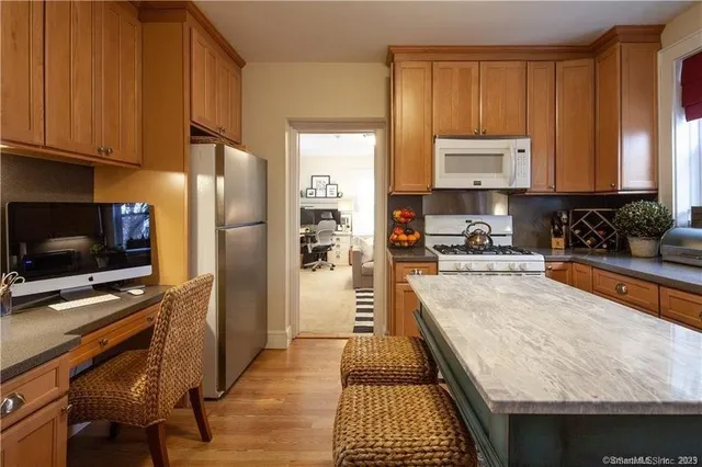 a kitchen with stainless steel appliances a stove a sink a refrigerator and cabinets