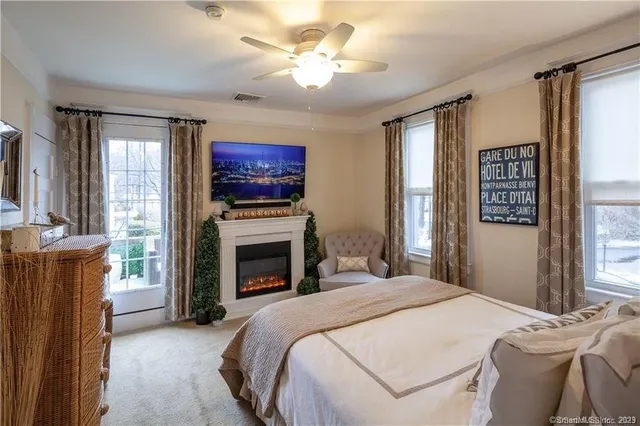 a bedroom with a bed dresser and a fireplace