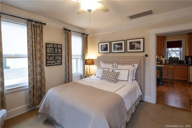 a bedroom with a large bed and a chandelier