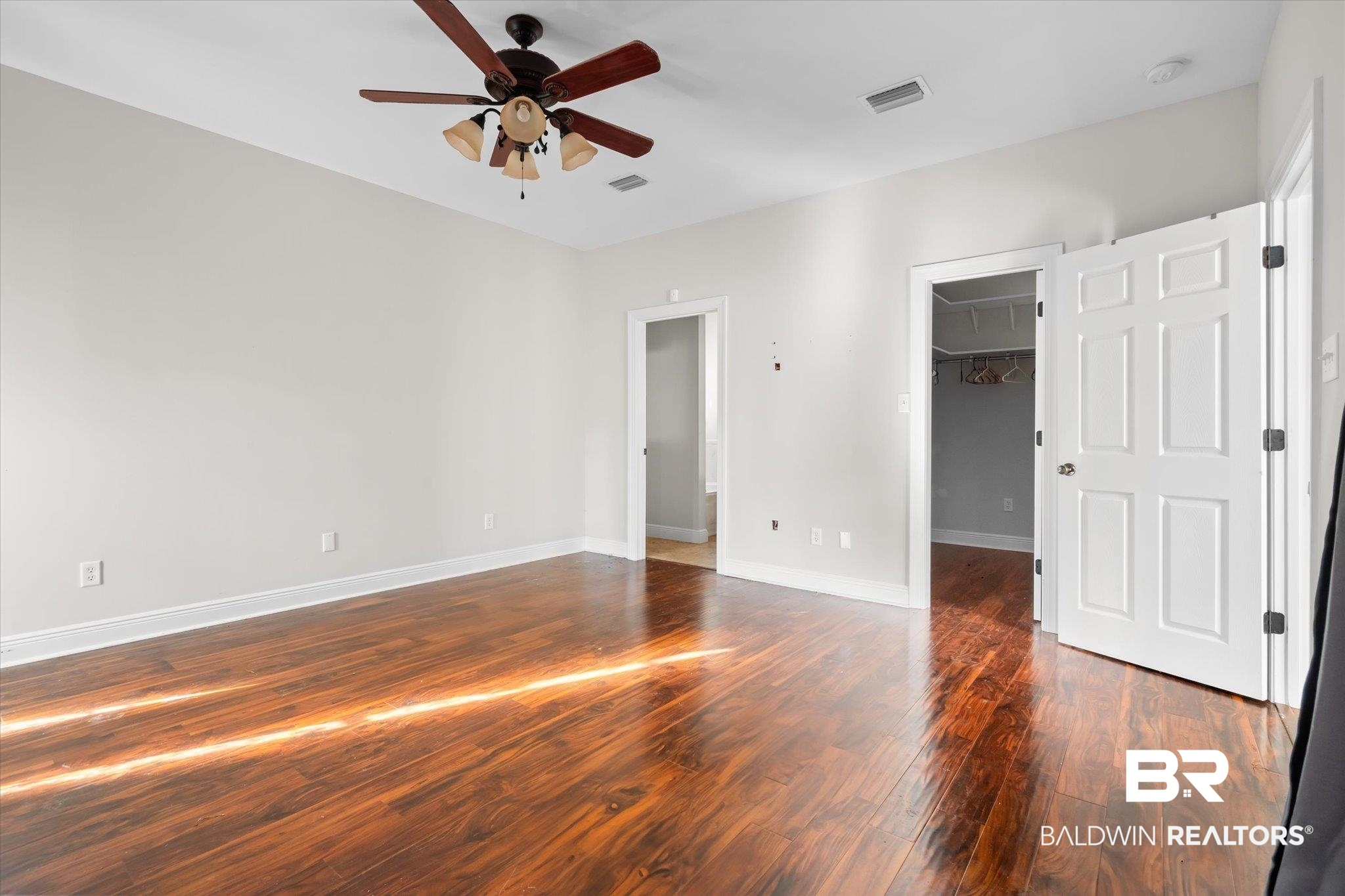 20792 Lonnie Walker Road Citronelle, AL 36522 - Photo 7 of 19 Unfurnished bedroom with dark hardwood / wood-style flooring, a spacious closet, a closet, and ceiling fan