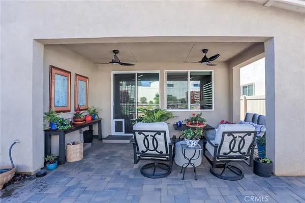 a living room with patio furniture and a potted plant