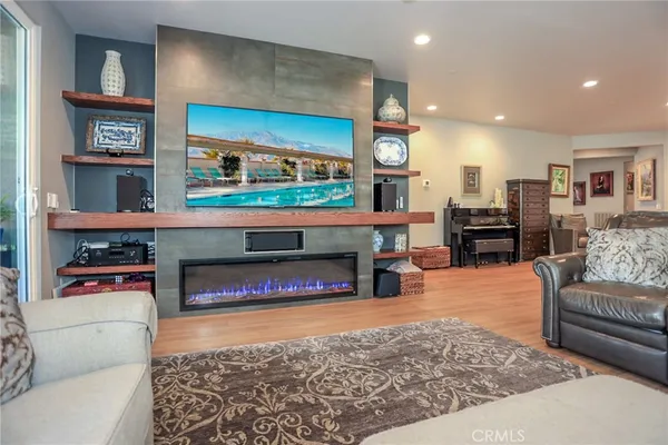 a living room with furniture a flat screen tv and a fireplace