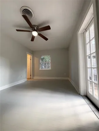 an empty room with windows and ceiling fan view