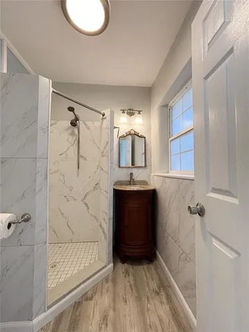 a bathroom with a granite countertop sink a mirror and a bathtub