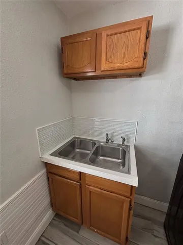 a kitchen with stainless steel appliances granite countertop wooden cabinets and a wooden floor