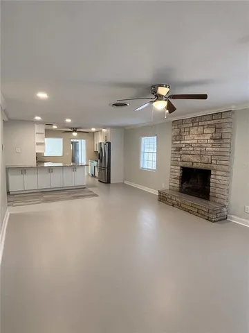 an empty room with windows and fireplace