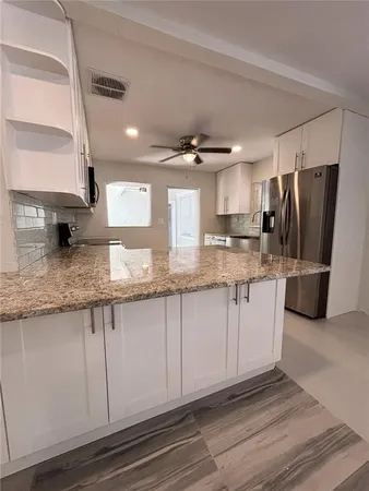 a view of a refrigerator in kitchen and wooden floor