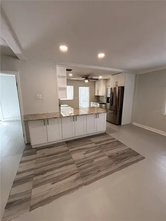 an empty room with windows and fireplace