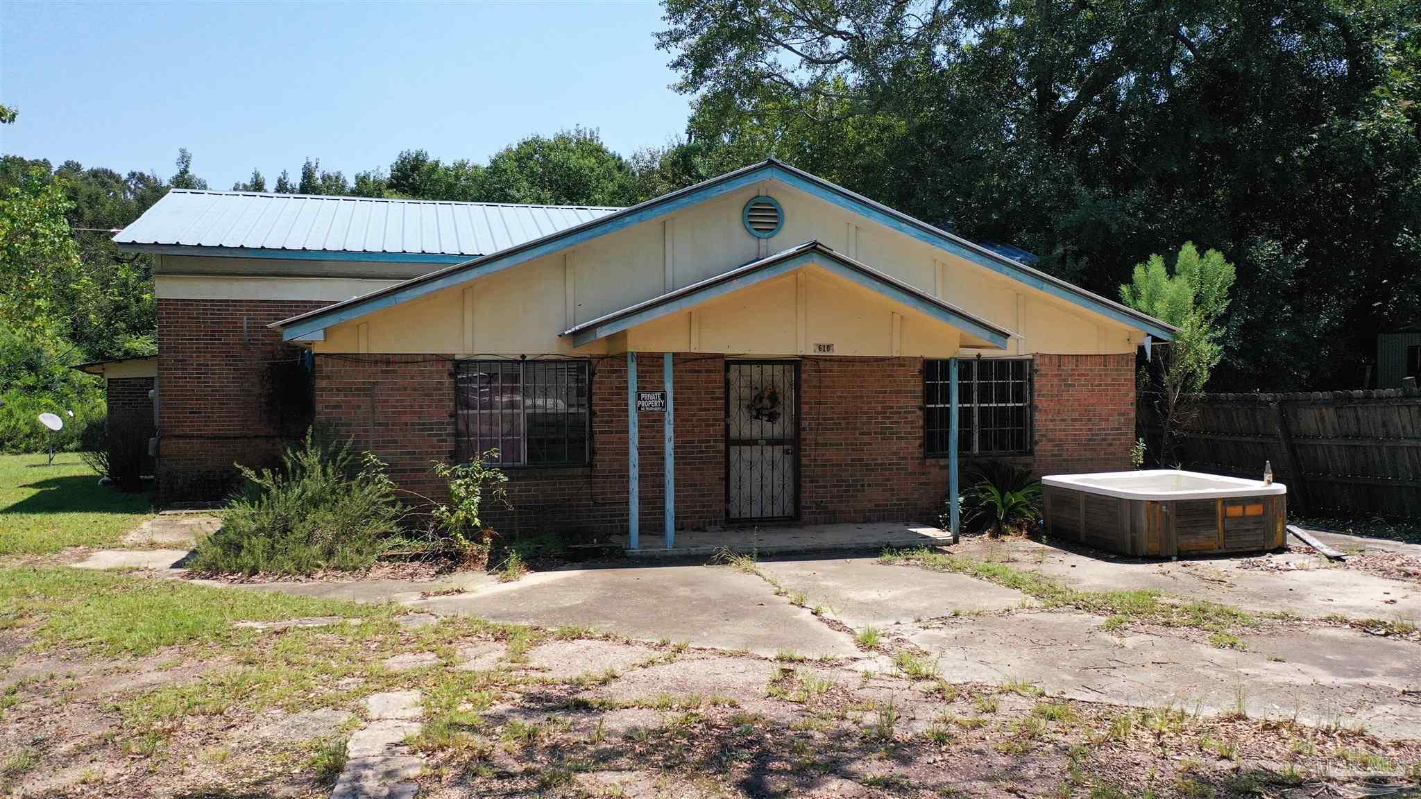 612 North Main Street Atmore, AL 36502 - Photo 6 of 12 a front view of a house with a yard and garage