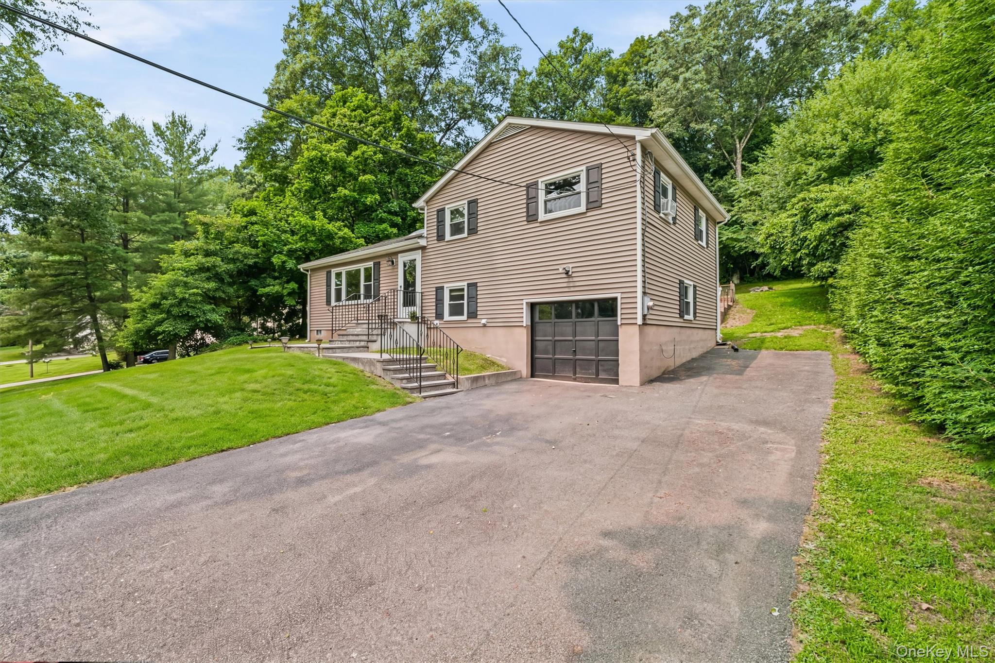 17 Ridge Road Cortlandt Manor, NY 10567 - Photo 2 of 38 Large flat driveway, one-car garage and extra parking pad on side.