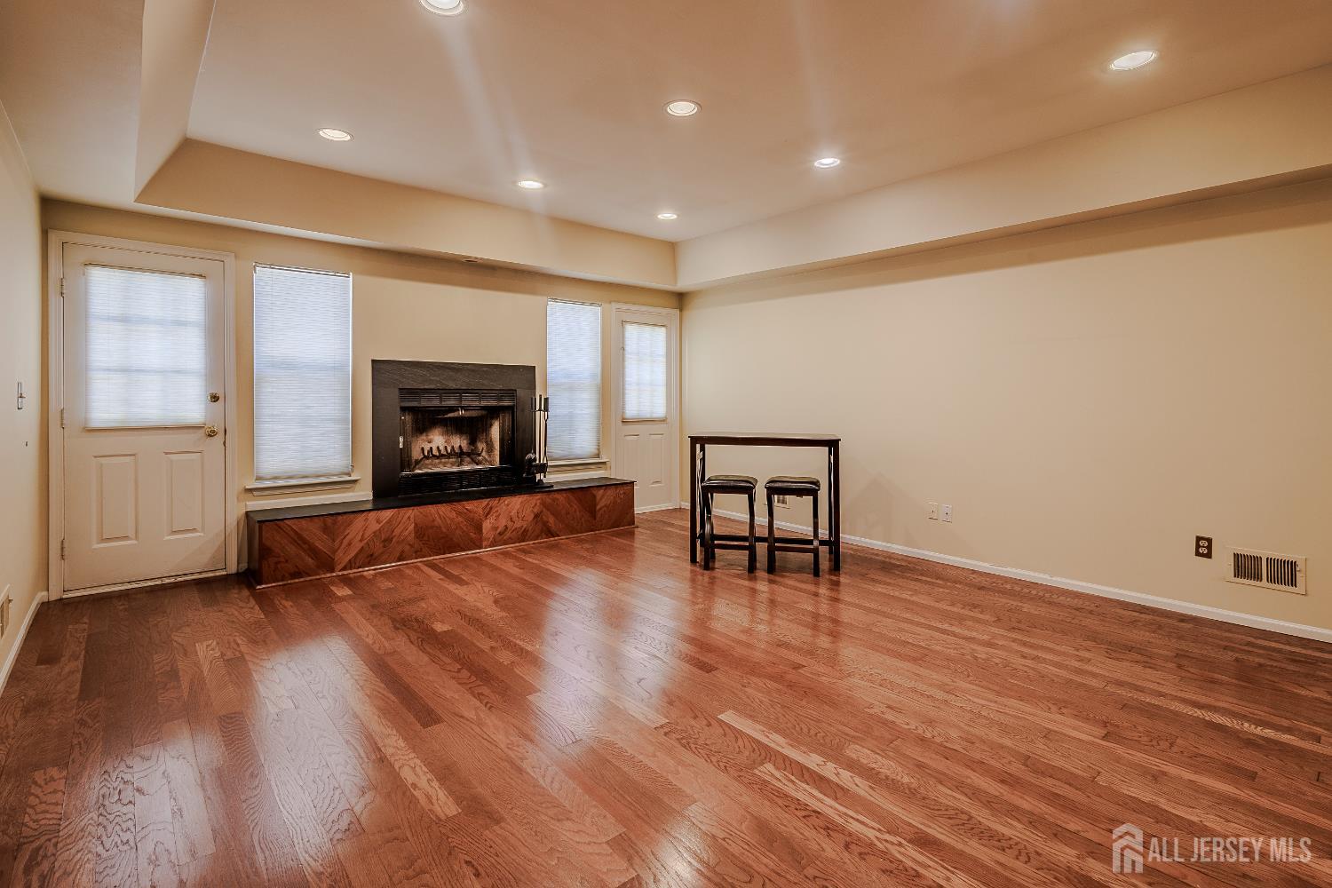412 Hawkshead Way Somerset, NJ 08873 - Photo 12 of 35 an empty room with wooden floor fireplace and windows