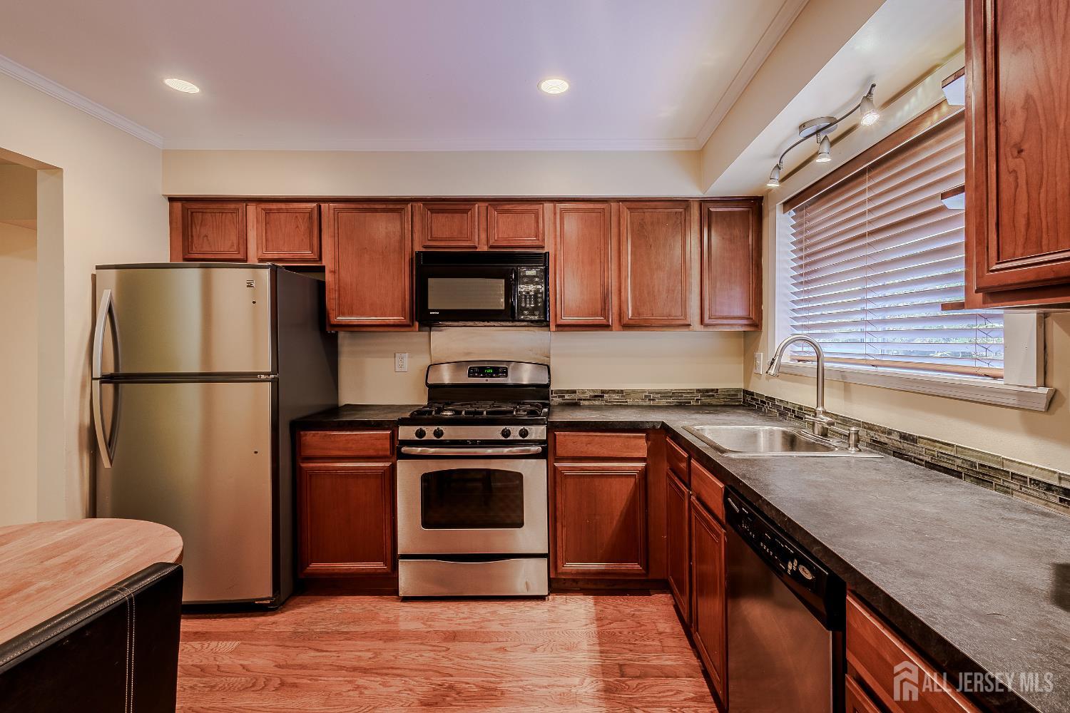 412 Hawkshead Way Somerset, NJ 08873 - Photo 8 of 35 a kitchen with stainless steel appliances granite countertop a refrigerator stove a sink and a microwave