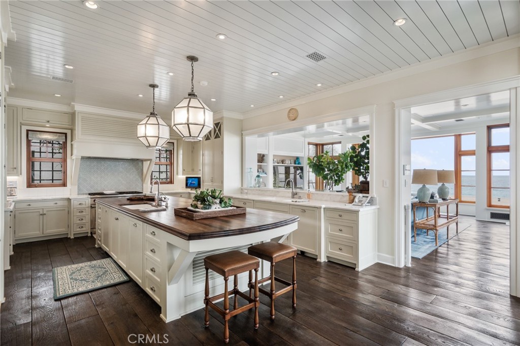 212 The Strand Manhattan Beach, CA 90266 - Photo 19 of 75 a kitchen with stainless steel appliances a dining table chairs stove and white cabinets