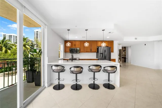 a kitchen with kitchen island a counter top space cabinets stainless steel appliances and a large window