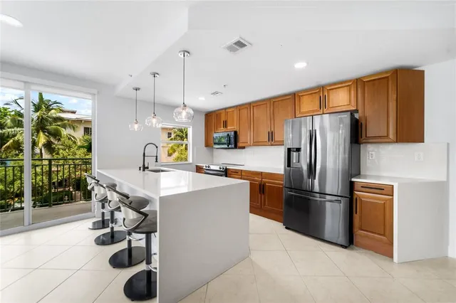 a kitchen with stainless steel appliances a sink and large windows