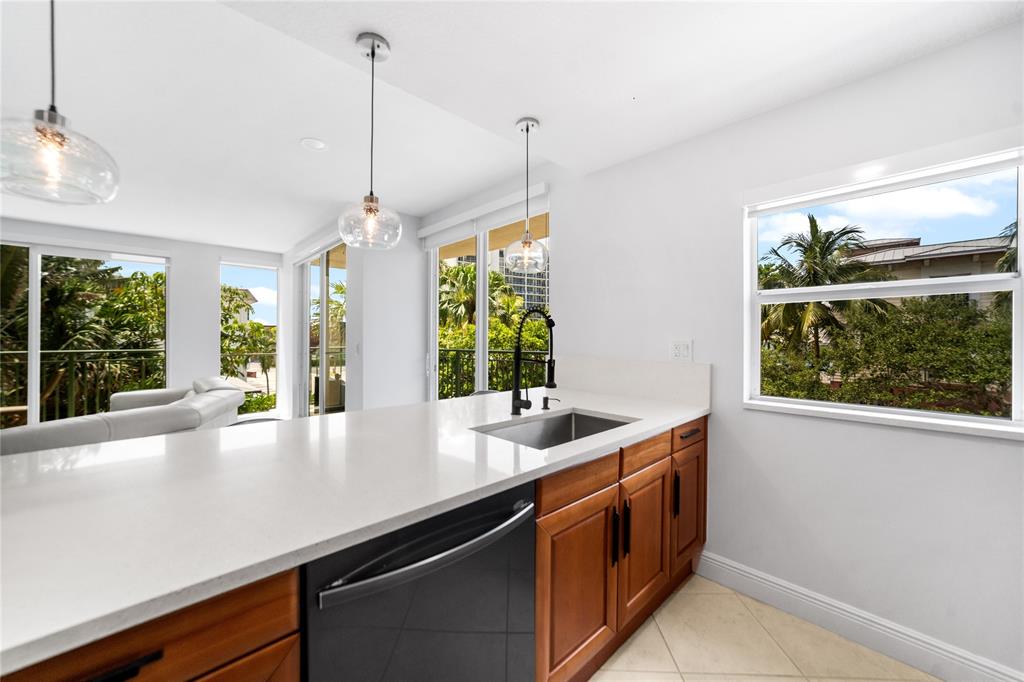 3210 Northeast 5th Street, Unit 203 Pompano Beach, FL 33062 - Photo 15 of 61 a kitchen with stainless steel appliances a sink and large windows