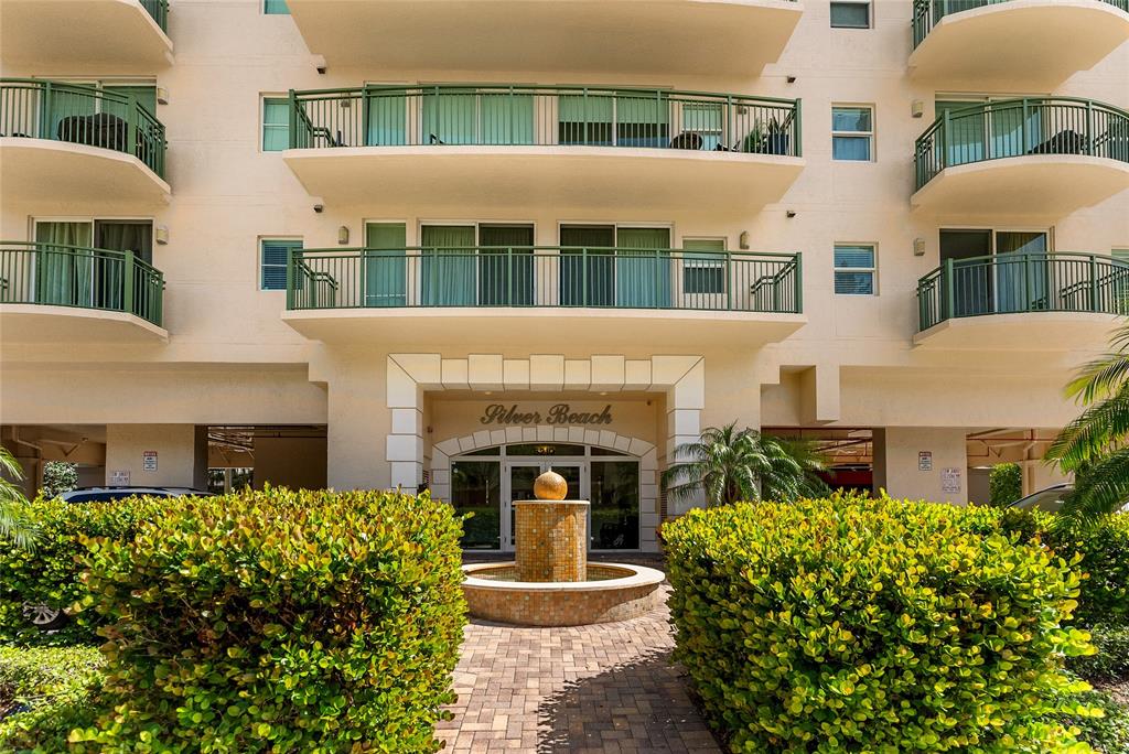 3210 Northeast 5th Street, Unit 203 Pompano Beach, FL 33062 - Photo 20 of 61 a front view of a house with a yard and fountain