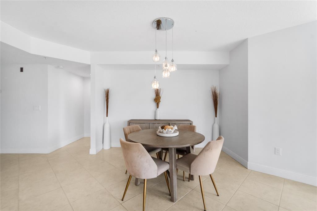 3210 Northeast 5th Street, Unit 203 Pompano Beach, FL 33062 - Photo 28 of 61 a view of a dining room with furniture and wooden floor