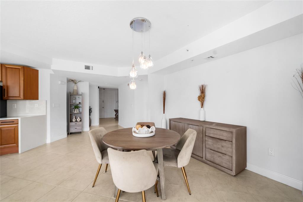 3210 Northeast 5th Street, Unit 203 Pompano Beach, FL 33062 - Photo 29 of 61 a view of a dining room with furniture and wooden floor