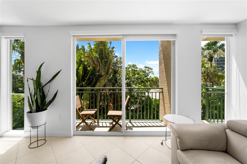 3210 Northeast 5th Street, Unit 203 Pompano Beach, FL 33062 - Photo 30 of 61 a living room with patio furniture and a floor to ceiling window