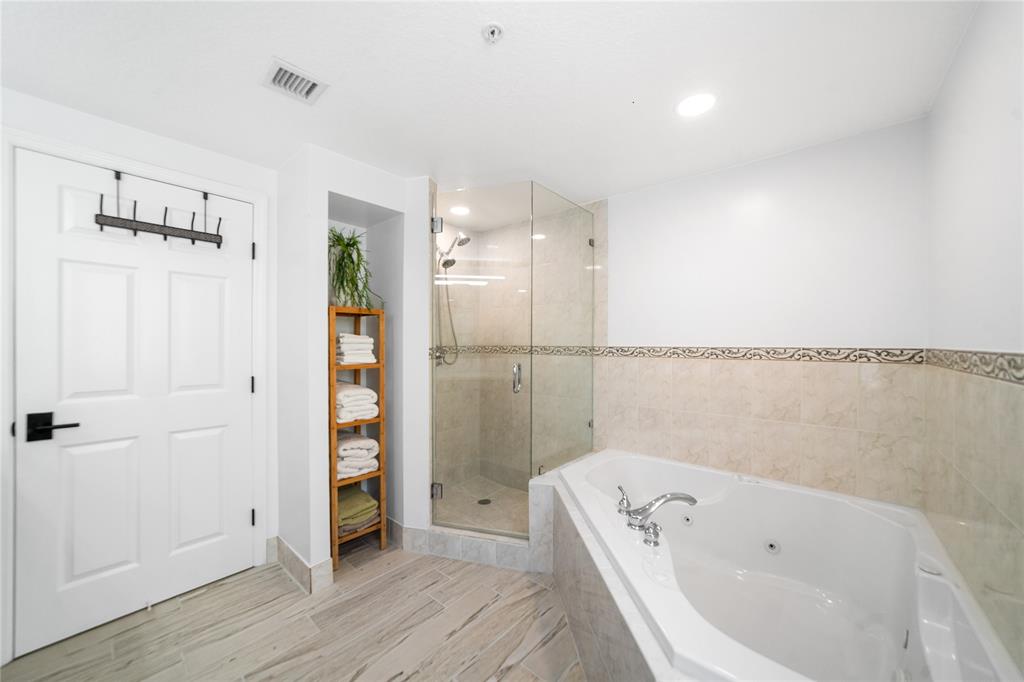 3210 Northeast 5th Street, Unit 203 Pompano Beach, FL 33062 - Photo 34 of 61 a bathroom with a tub a sink and a wooden floor