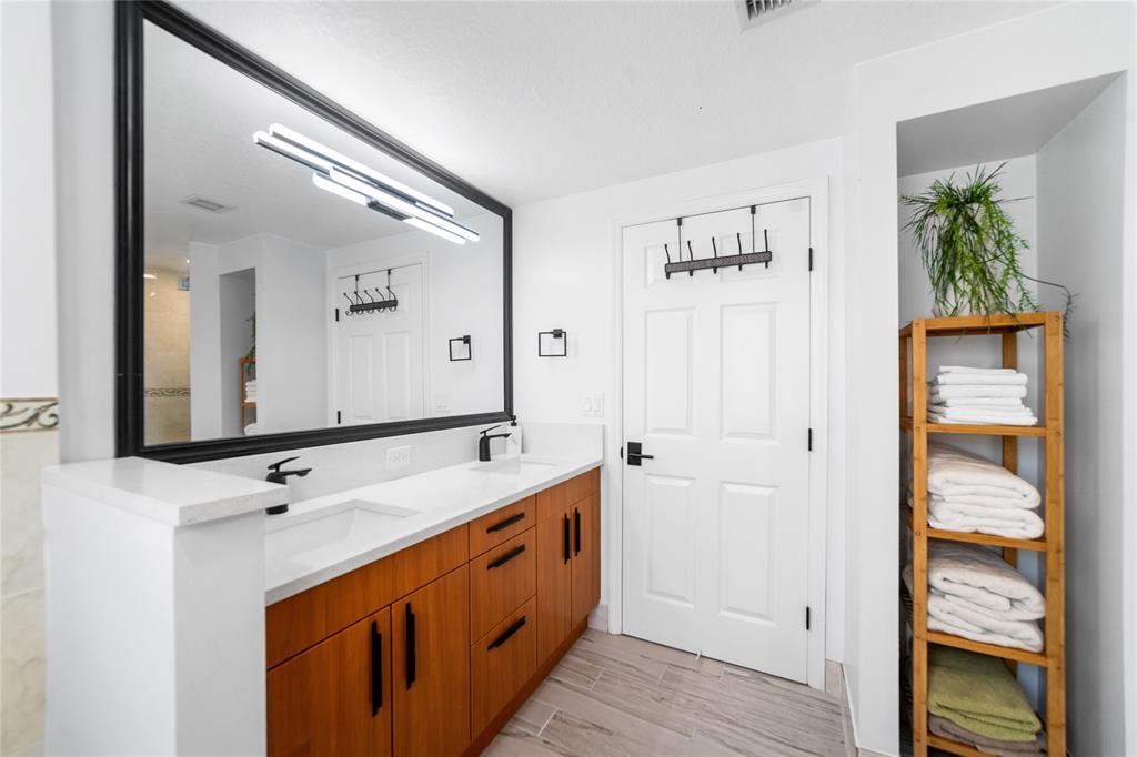 3210 Northeast 5th Street, Unit 203 Pompano Beach, FL 33062 - Photo 35 of 61 a bathroom with a double vanity sink and a mirror