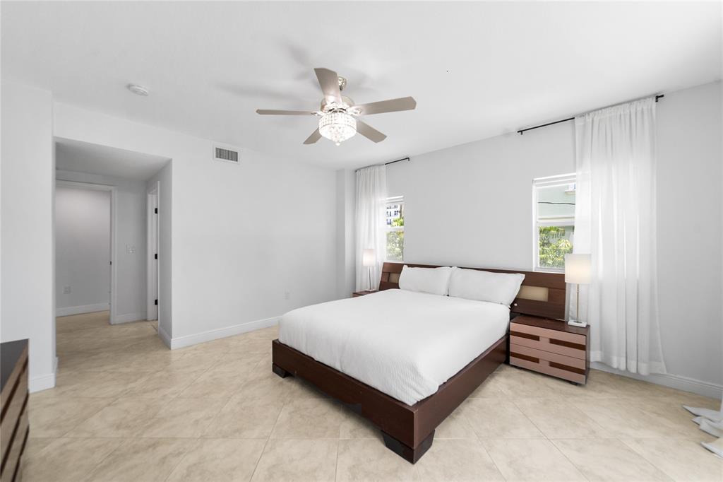 3210 Northeast 5th Street, Unit 203 Pompano Beach, FL 33062 - Photo 38 of 61 a bedroom with a bed and a ceiling fan