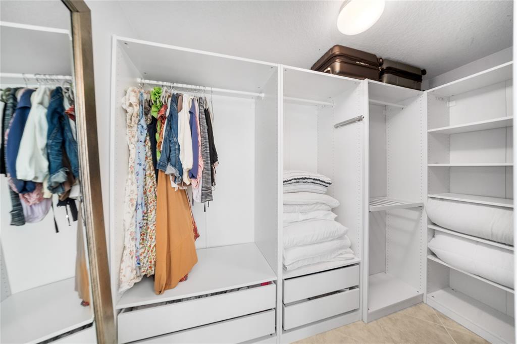 3210 Northeast 5th Street, Unit 203 Pompano Beach, FL 33062 - Photo 40 of 61 a view of walk in closet with clothes and shoes