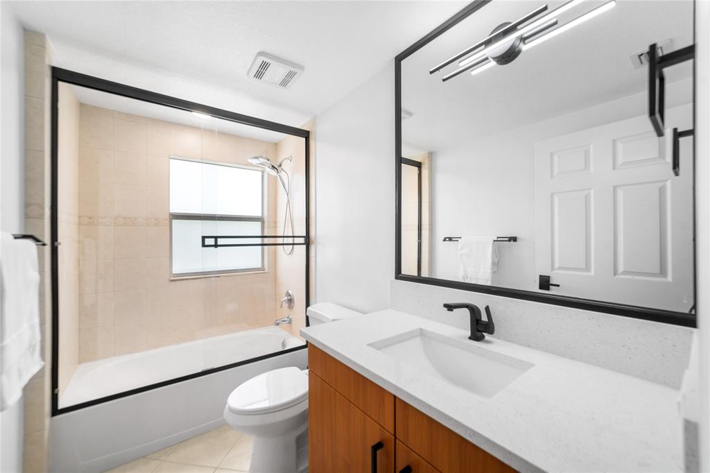 3210 Northeast 5th Street, Unit 203 Pompano Beach, FL 33062 - Photo 44 of 61 a bathroom with a sink a toilet and a mirror