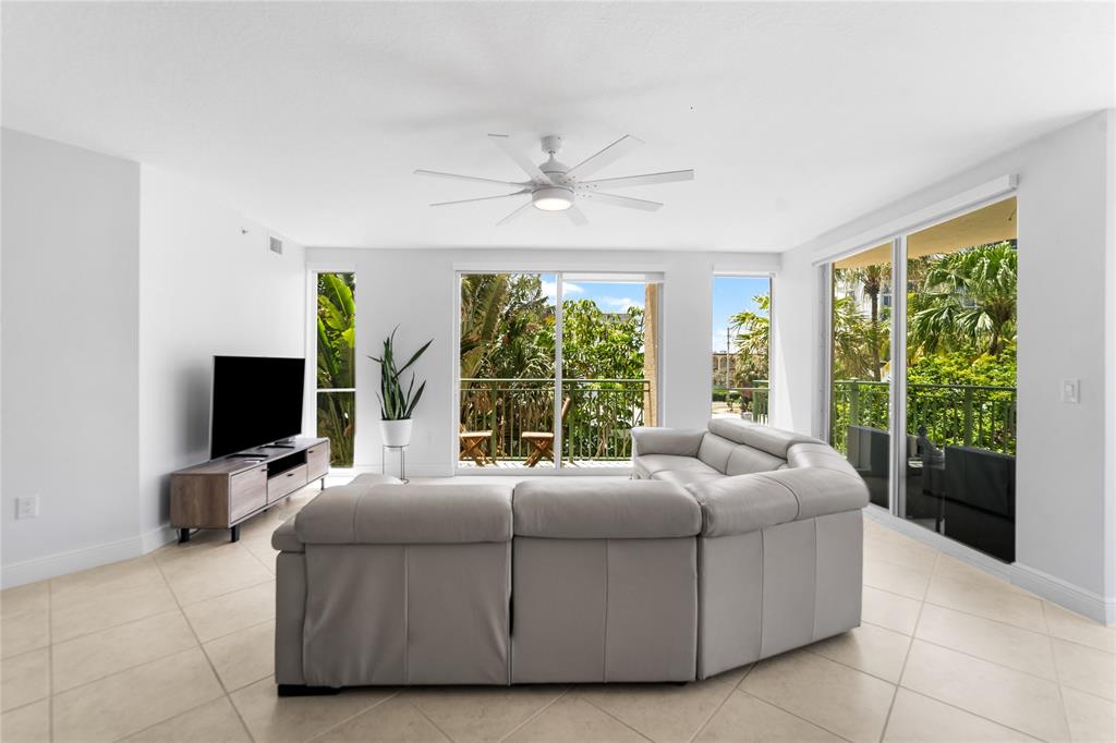 3210 Northeast 5th Street, Unit 203 Pompano Beach, FL 33062 - Photo 10 of 61 a living room with couch tv and large window