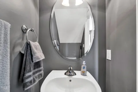 a bathroom with a sink and mirror with bathtub
