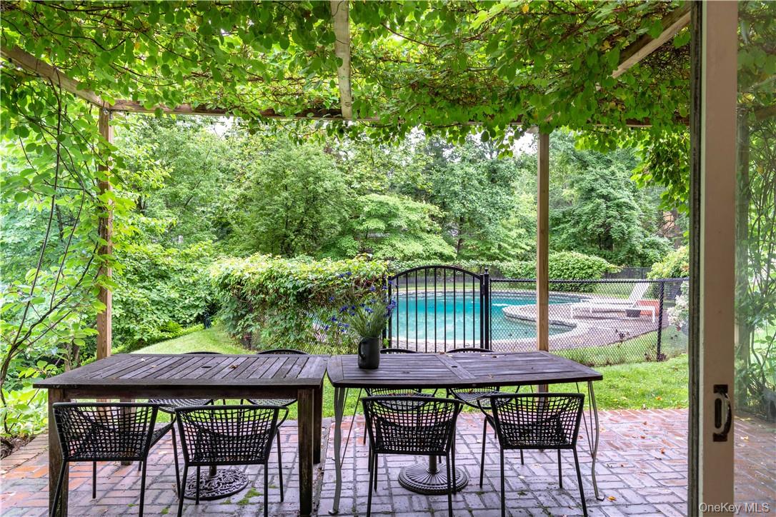 21 Woods Road Palisades, NY 10964 - Photo 6 of 47 a view of a patio with table and chairs under an umbrella with wooden fence and floor