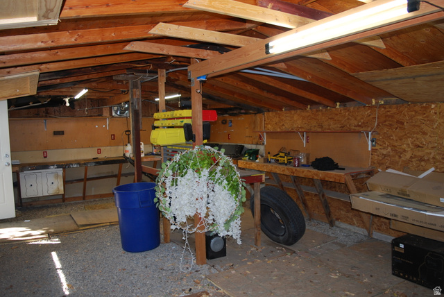 116 North 3rd Street Tooele, UT 84074 - Photo 42 of 45 Exposed wood beam ceiling, multiple built-in workbenches, integrated wall shelving, and fluorescent lighting fixtures