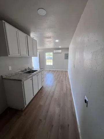 a view of a kitchen with wooden floor and electronic appliances