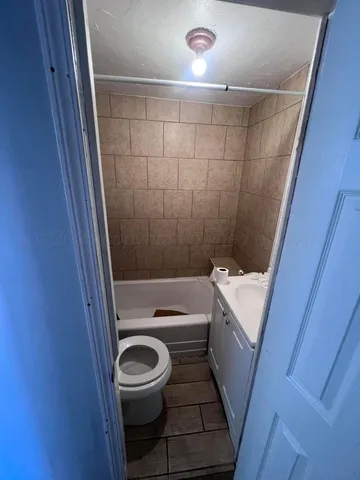 a bathroom with a sink a toilet a tub and shower
