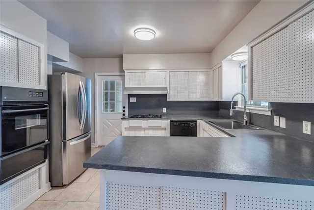a kitchen with granite countertop a refrigerator and a sink