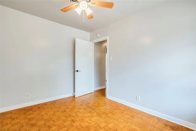 an empty room with a chandelier fan