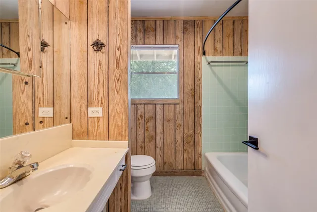 a bathroom with a sink a toilet a tub and shower
